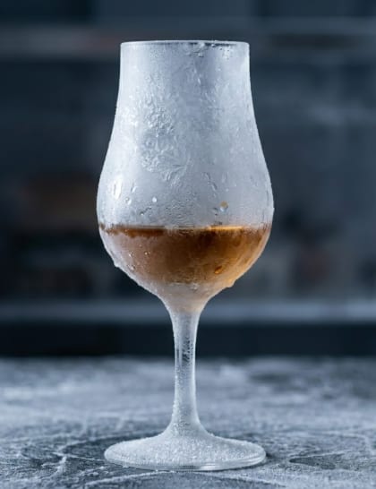 A cold glass straight from the freezer, covered in frost