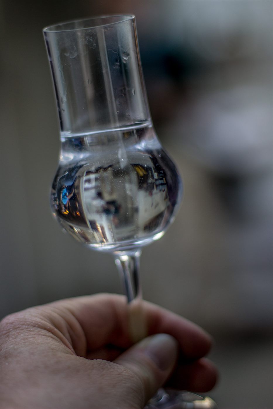A clear, stemmed tulip-shaped nosing glass for fruit brandy, bulging at the belly and narrowing at the mouth